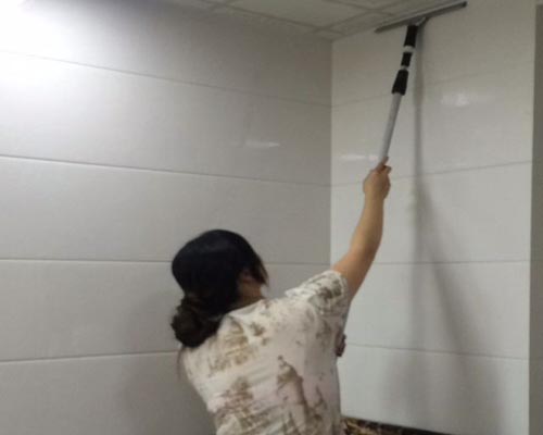 保潔人員在清洗衛生間牆麵